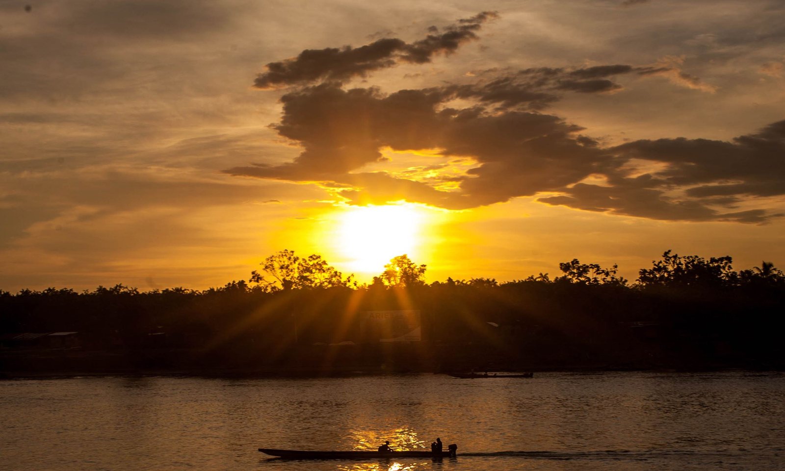 Atardecer sobre un río con una canoa