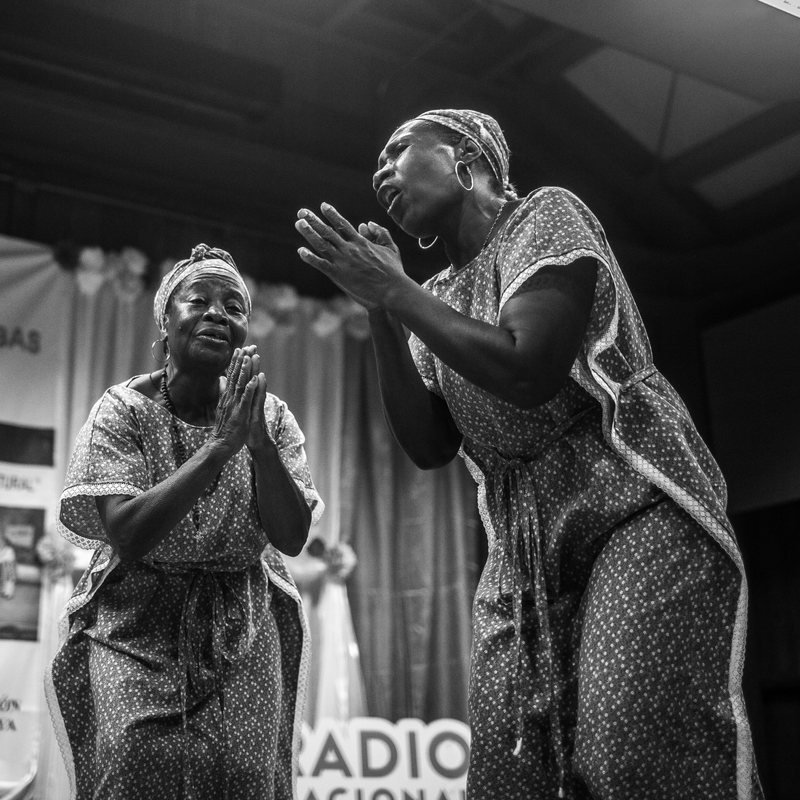 Mujeres afrodescendientes cantando en un escenario